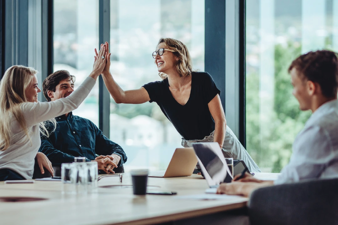 female team lead giving her team members high-fives in celebration